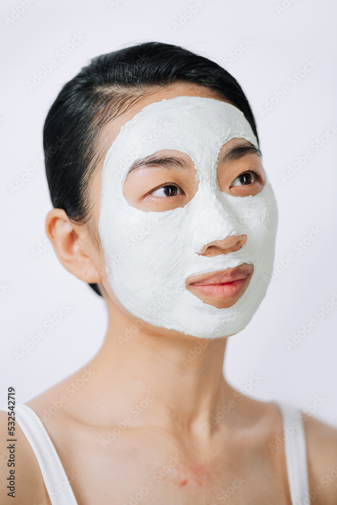 Beautiful Asian woman with facial mask on white background Beautiful Asian woman with facial mask on white background
