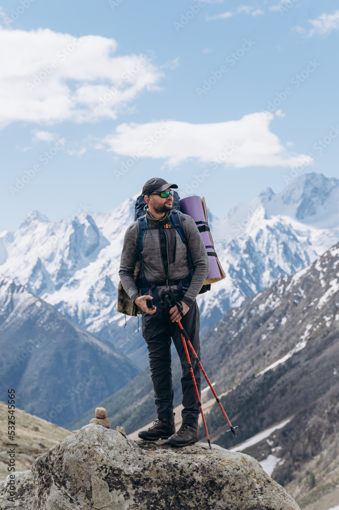 Man standing on stone and observing mountains Man standing on stone and observing mountains