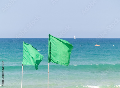 Green flags on coastal background.