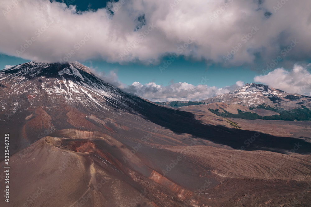 Fototapeta premium Vista aérea al volcan lonquimay con cielo azul y nubes en la reserva nacional malalcahuello en el sur de chile