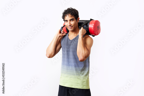 Content Hispanic sportsman exercising with sandbag