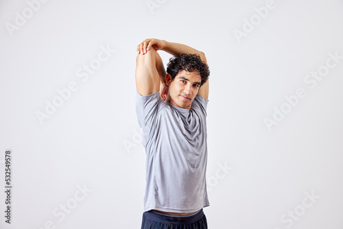 Hispanic sportsman stretching arm during training