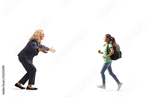 Schoolgirl holding a book and running to hug her mother