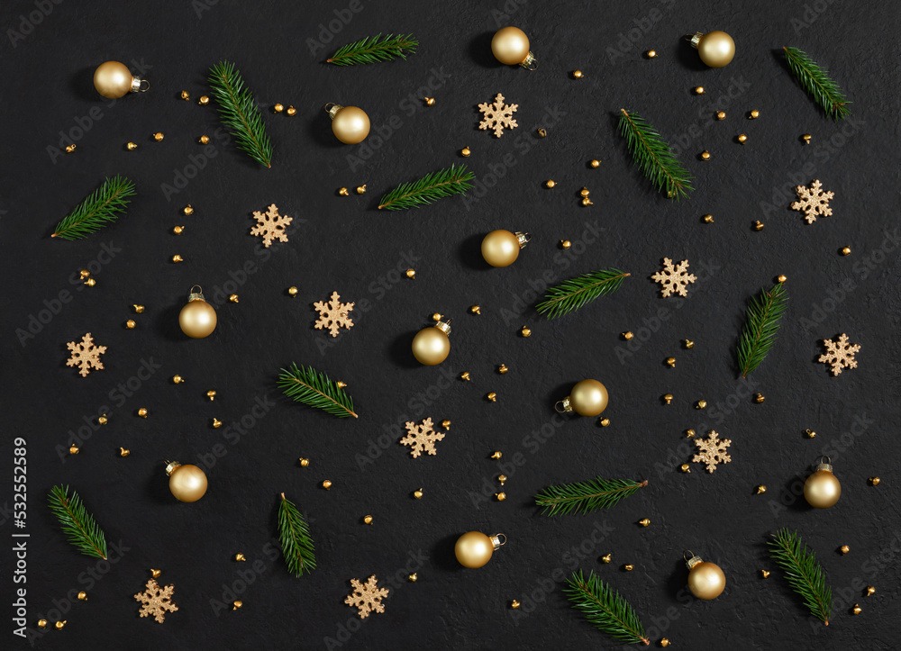 Christmas pattern with fir branches, golden baubles and snowflakes on ablack background. New Year composition. Greeting card. Top view, flat lay.