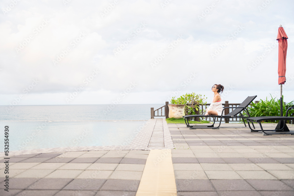 Beautiful woman sit and look into distance on lounger Beautiful woman sit and look into distance on lounger