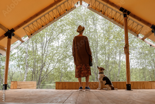 Woman with dog standing on lumber terrace photo