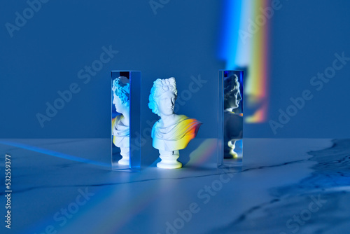 Antique bust and triangular prisms with rainbow. photo