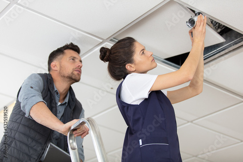 male and female workers inspecting ceiling for leaks