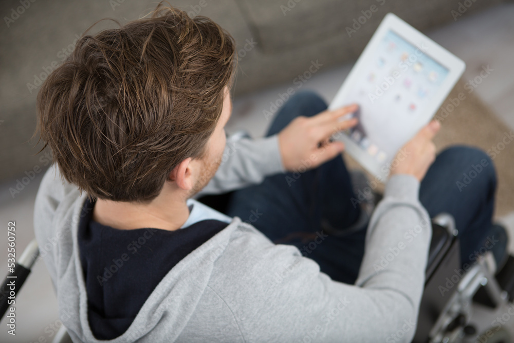 man in a wheelchair holding a tablet pc man in a wheelchair holding a tablet pc