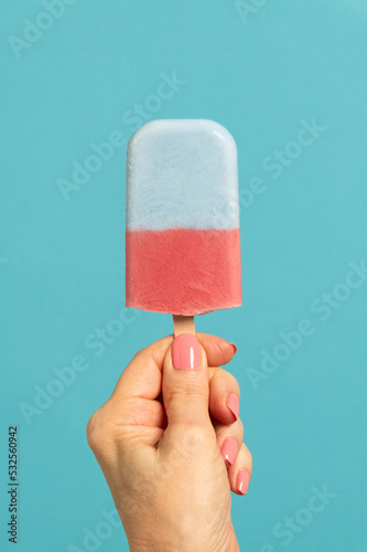 Woman holding homemade strawberry spirulina ice cream popsicle