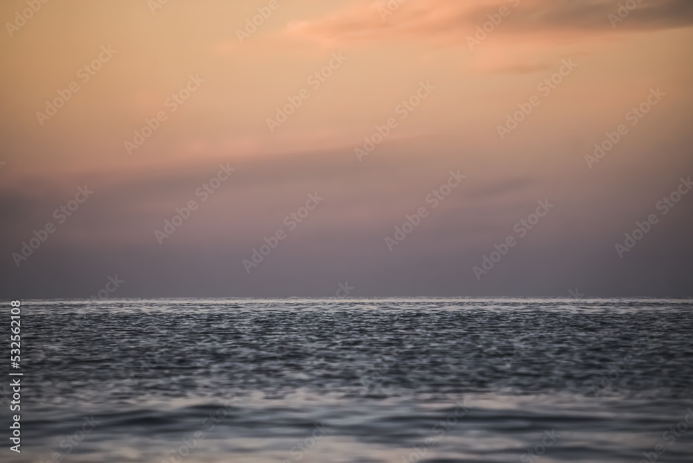 Water ripples on the surface of the Black Sea and the horizon of the sea and sky in soft twilight lighting after sunset
