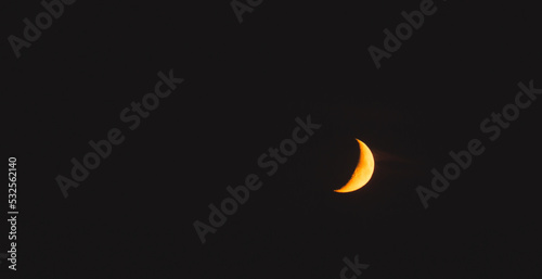 Waxing moon at orange sunrise, minimalistic sky, peaceful atmosphere panorama