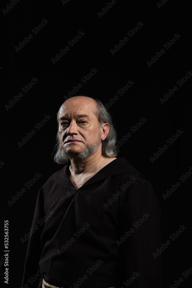 serious priest with grey hair and beard looking at camera isolated on black. serious priest with grey hair and beard looking at camera isolated on black.