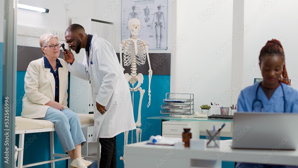 Obraz premium Otology specialist using otoscope to do ear examination with senior woman in cabinet, consulting patient with otolaryngology instrument. Doing ent consultation for audiology diagnosis.