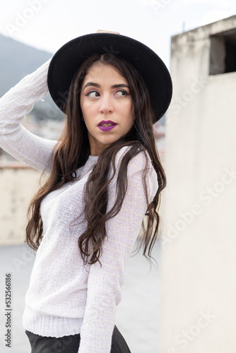 holding her hat beautiful young woman with long white skin hair wearing makeup, natural beauty of latin model in daytime © Alejandro