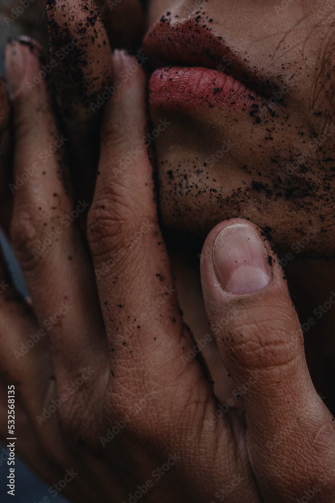 © Anastasia Mihaylova (Shpara)/Stocksy - A woman's portrait Close Up with red lips and back sand on the face