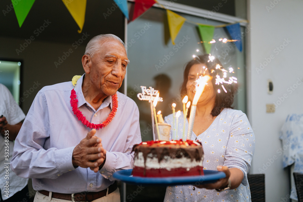 Old man blowing the candles of his birthday cake Stock Photo | Adobe Stock