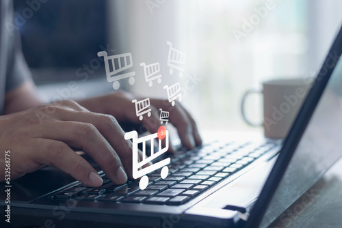 Business people use computer laptop for ordering online shopping on a shopping cart virtual screens. And online payment option or digital wallet online transaction and e-commerce technology concept. photo