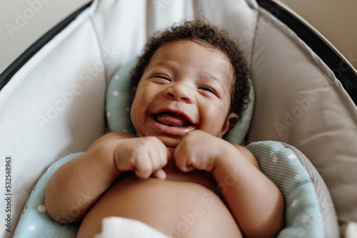 Adorable baby boy laughing in a bouncer