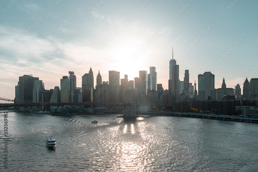 Sunset over East River and financial district Manhattan, NYC. View of Brooklyn Bridge and shade of it
