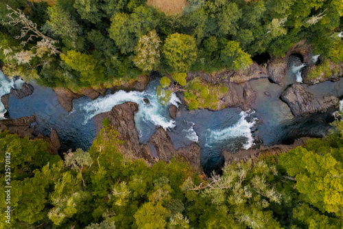 Imagen aerea cenital de rio fuy en la ciudad de neltume cerca del salto huilo huilo. Vista desde dron pasando por rio hasta llegar al bosque photo