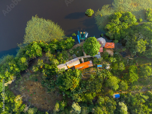 Aerial view of a local guest house in the amazon rainforest with a little pier and small wooden shacks photo