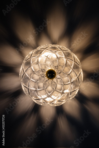 openwork vintage glass sconce lamp with light shadows on the wall