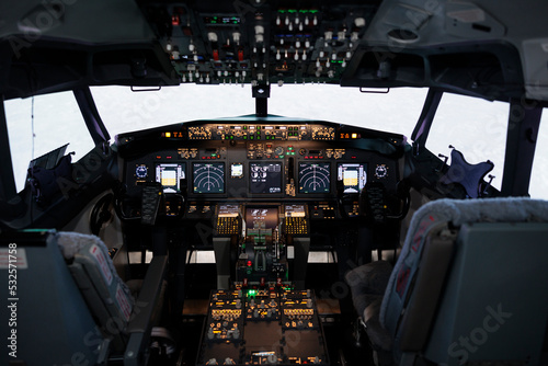 No people in captain cockpit with power engine lever to fly airplane, using dashboard command buttons and control panel navigation. Windscreen and radar compass handle, airline travel.