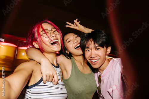 Cheerful chinese friends taking selfie at night photo