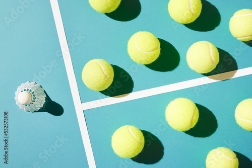 Bunch of tennis balls against badminton shuttlecock