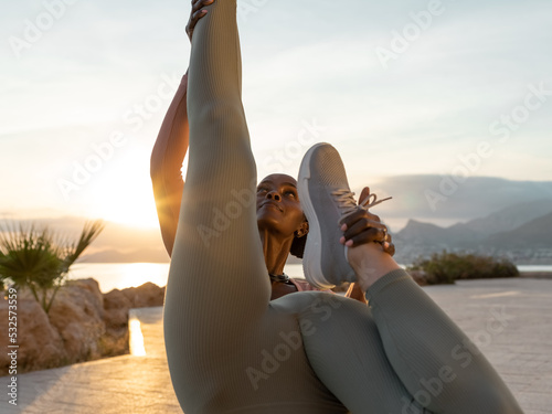 Black woman helping girlfriend to do yoga photo