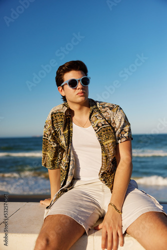 Stylish man chilling near sea photo