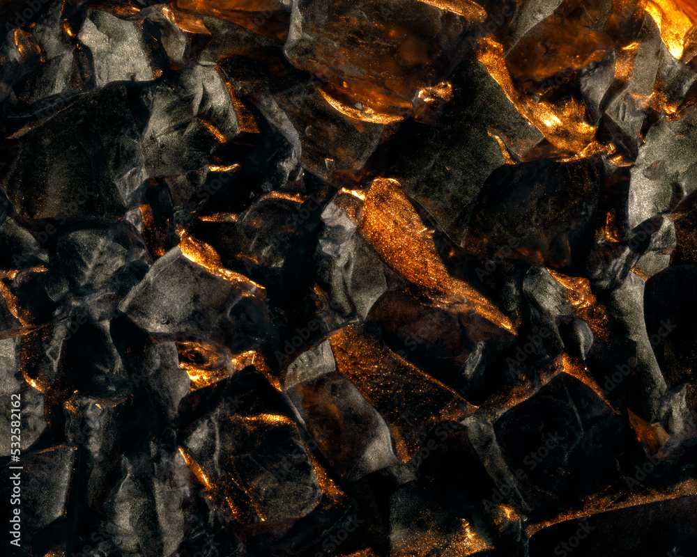 Dark black stones glittering with shiny golden light. Dark black stones glittering with shiny golden light.