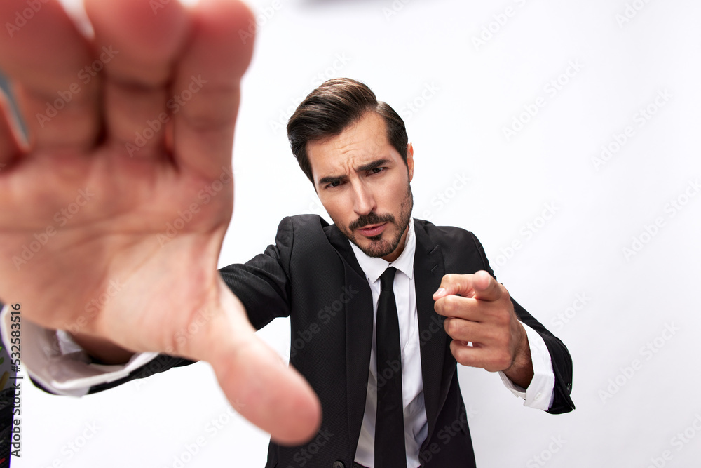 Portrait of a man in an expensive business suit close-up of a wide-angle lens pulling his hands into the camera with his mouth open and pointing his finger at the white background Portrait of a man in an expensive business suit close-up of a wide-angle lens pulling his hands into the camera with his mouth open and pointing his finger at the white background