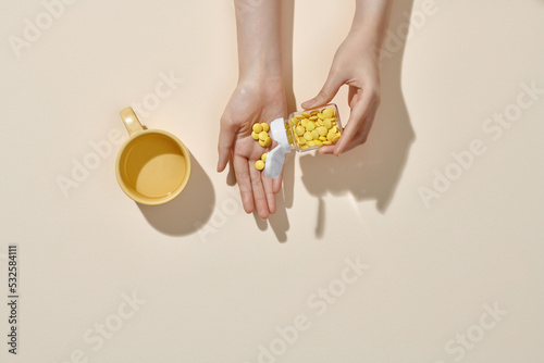 woman pours out from bottle pills into palm photo