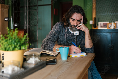 Man writing in notebook at home