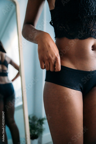 Unrecognizable woman in underwear standing in room photo