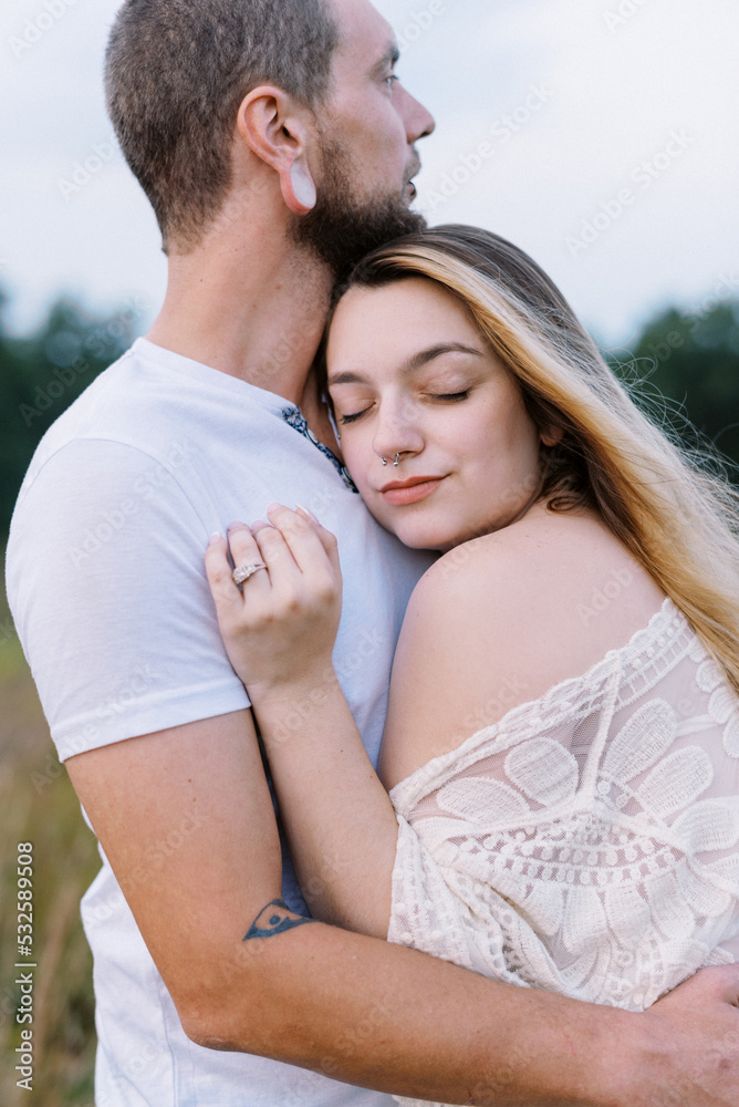close up portrait of young happy engaged couple hugging during sunset close up portrait of young happy engaged couple hugging during sunset