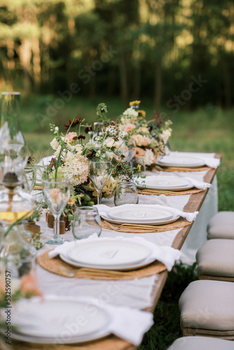 close up of wedding reception table setting with flower arrangements photo