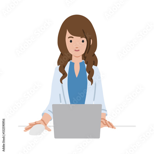 デスクで座ってPCを使っているジャケットの女性