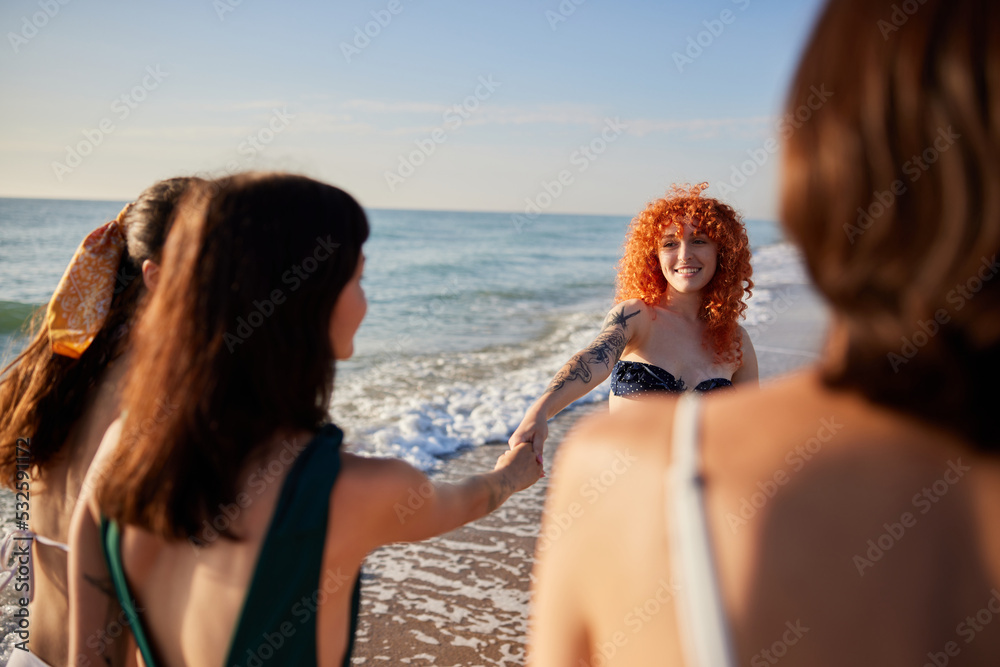 Happy young women walking near waving sea Happy young women walking near waving sea