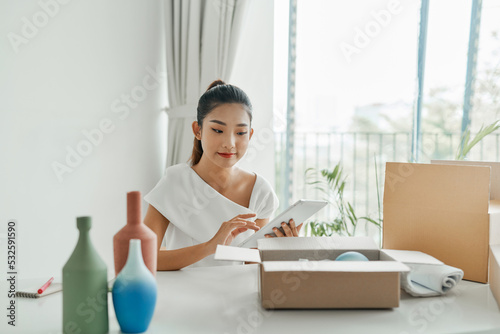 Asian young woman owner packing product, checking parcel box