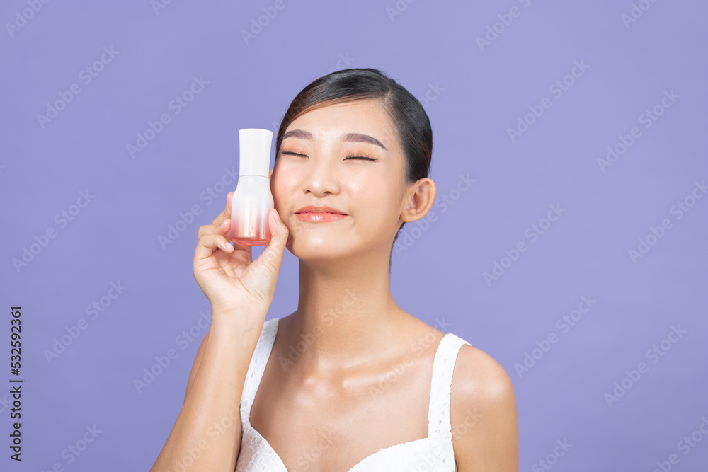 Pretty woman model holding a cosmetic bottle and smiling. Pretty woman model holding a cosmetic bottle and smiling.