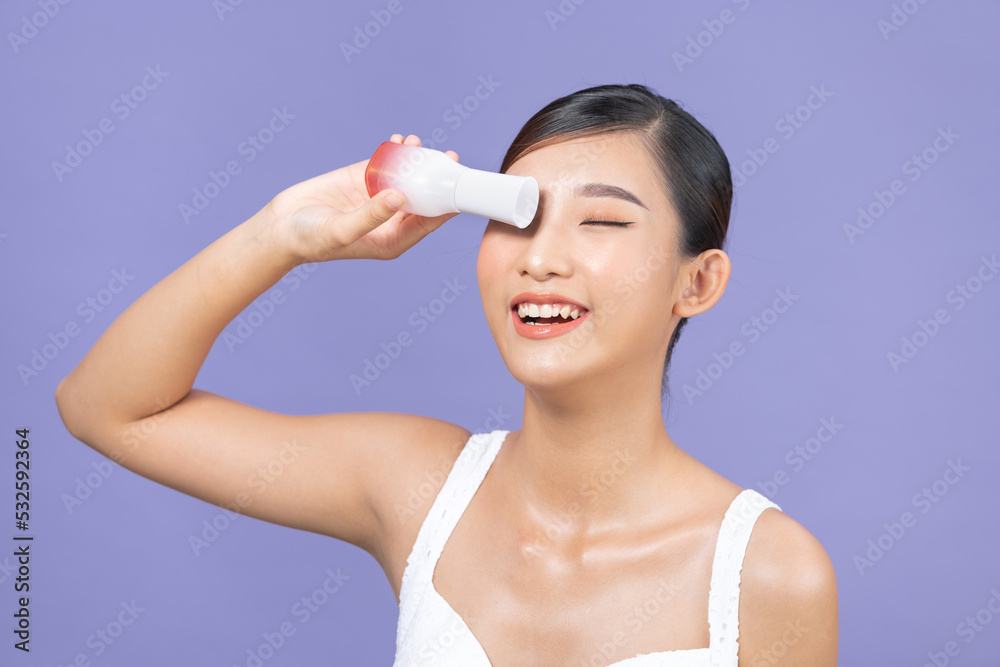 A beautiful Asian woman with a charming smile holding toner bottle A beautiful Asian woman with a charming smile holding toner bottle