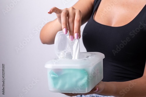 Woman in black tank top taking wet wipes from the disposable package - hygiene procedure and prevention of infectious diseases