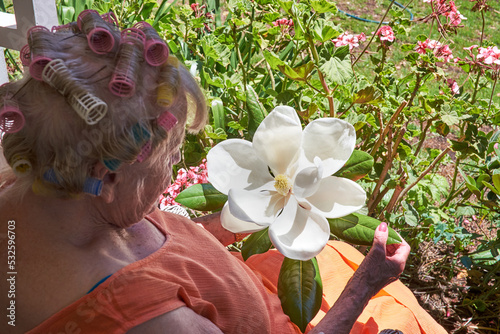 Senior lady looking at large flower
