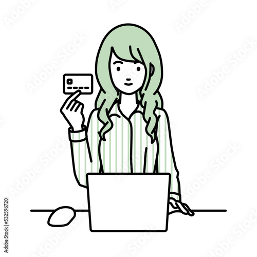 デスクで座ってPCを使いながらクレジットカードを手に持っているブラウスの女性