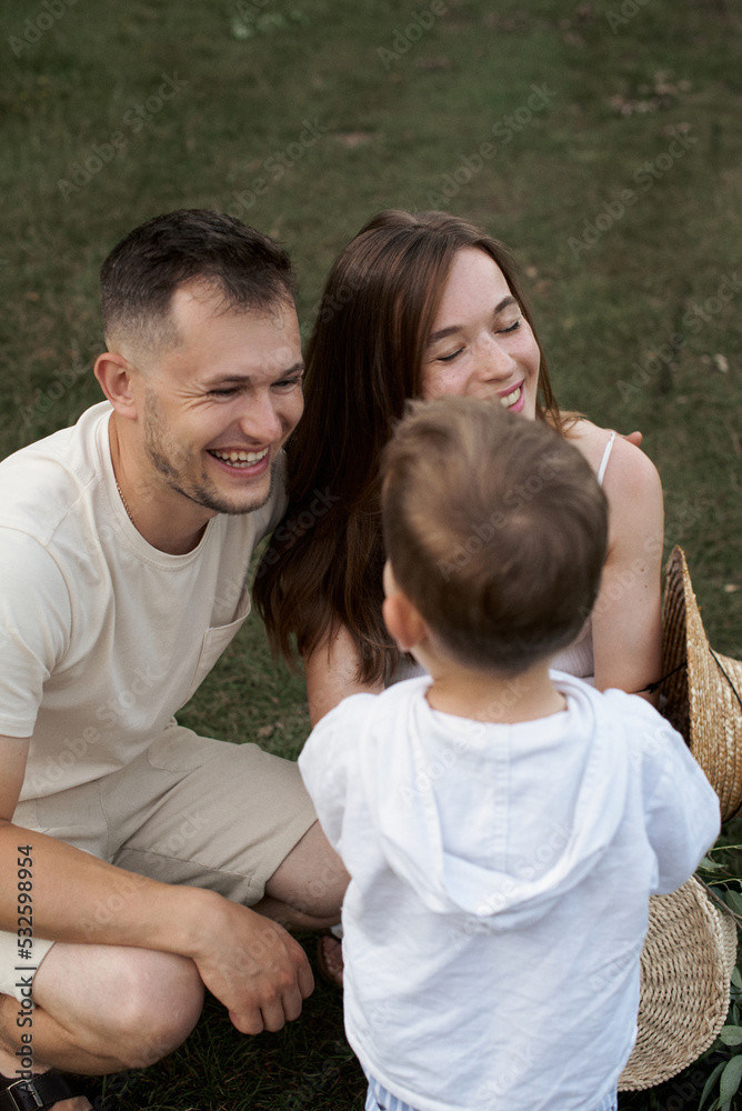 Young family with one child in summer meadow Young family with one child in summer meadow