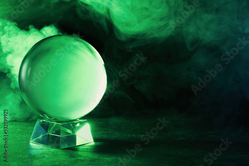 Photography Crystal ball on table and smoke against dark background, space for text