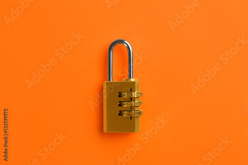 Modern combination lock on orange background, top view